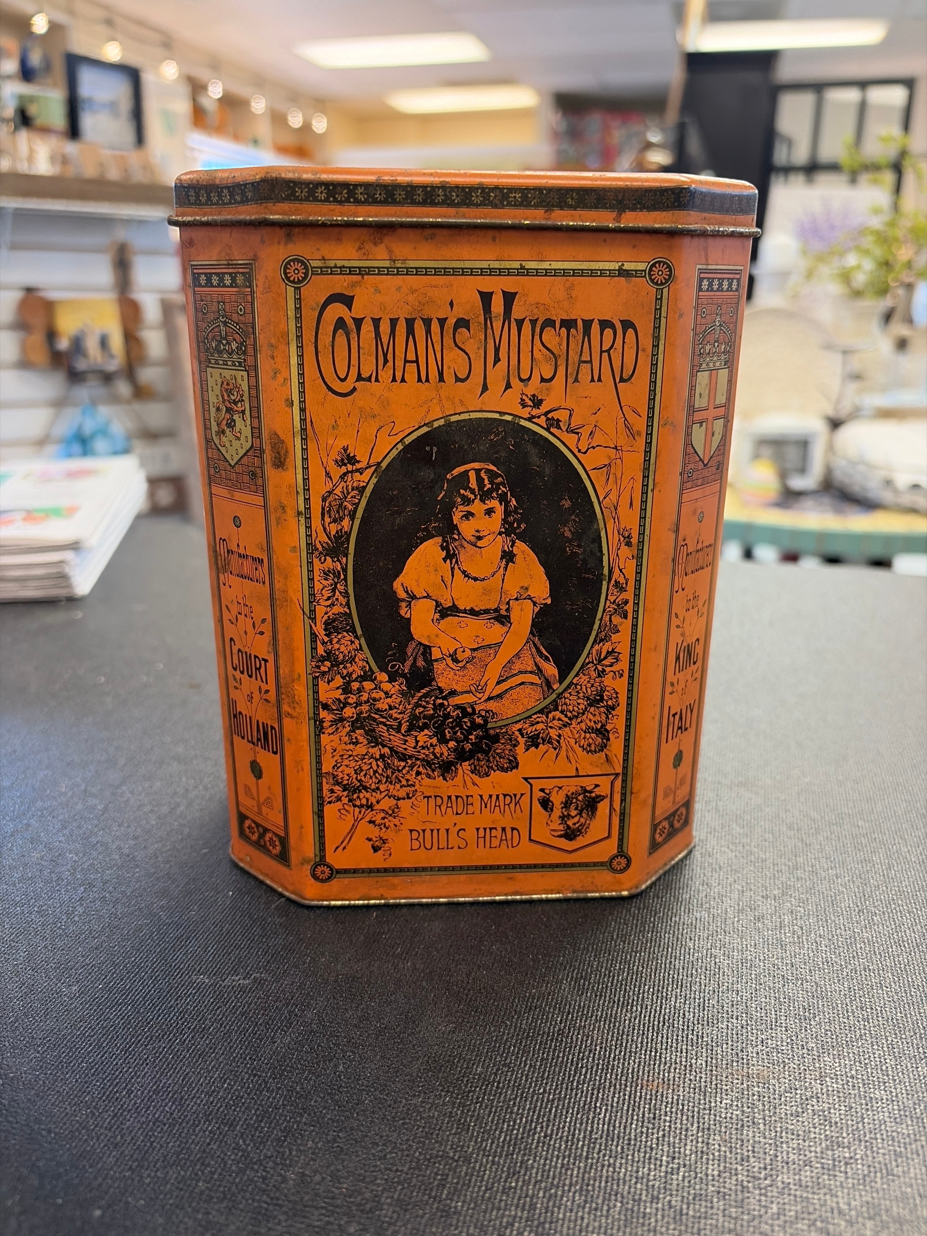 Vintage octagonal Colman's Mustard tin with a "Bull's Head" trademark and a portrait of a girl