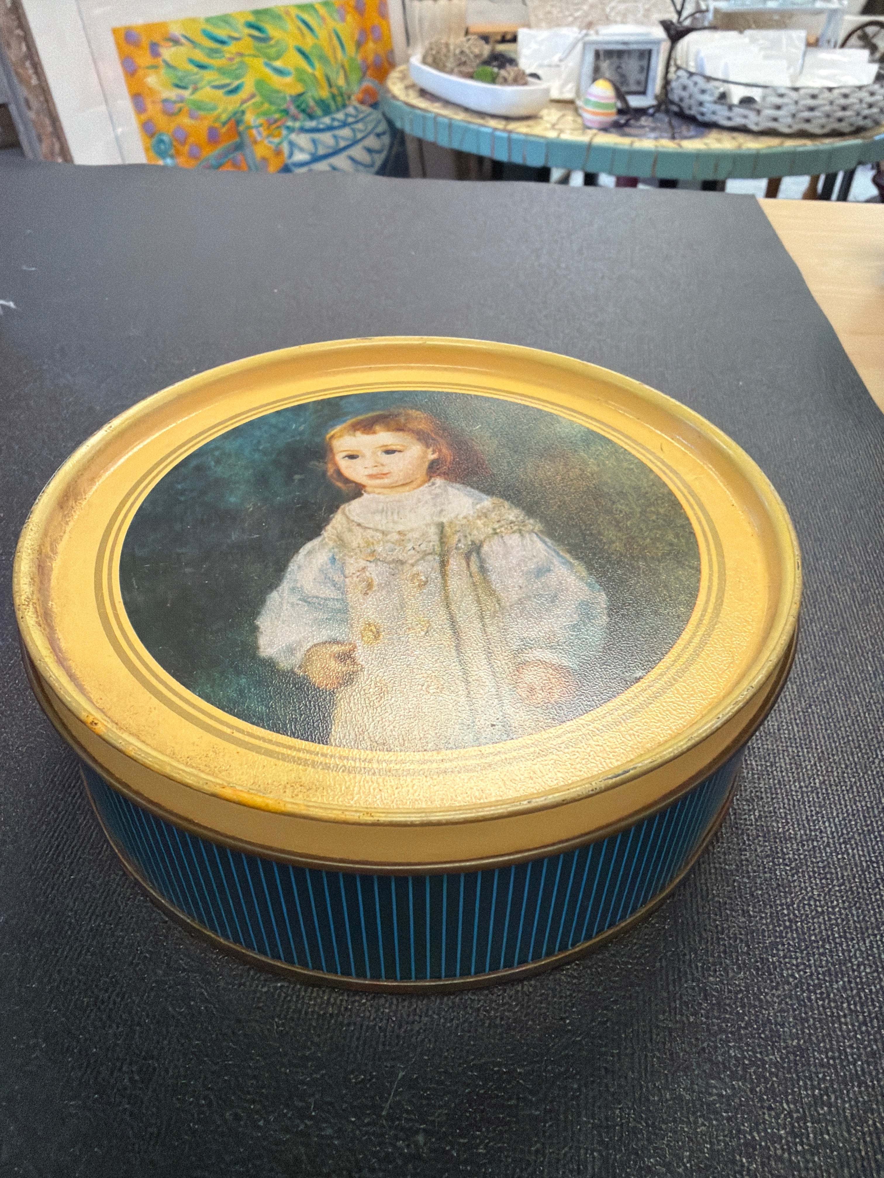 Vintage decorative tin featuring a reproduction of Pierre-Auguste Renoir's painting Lucie Berard (Child in White).