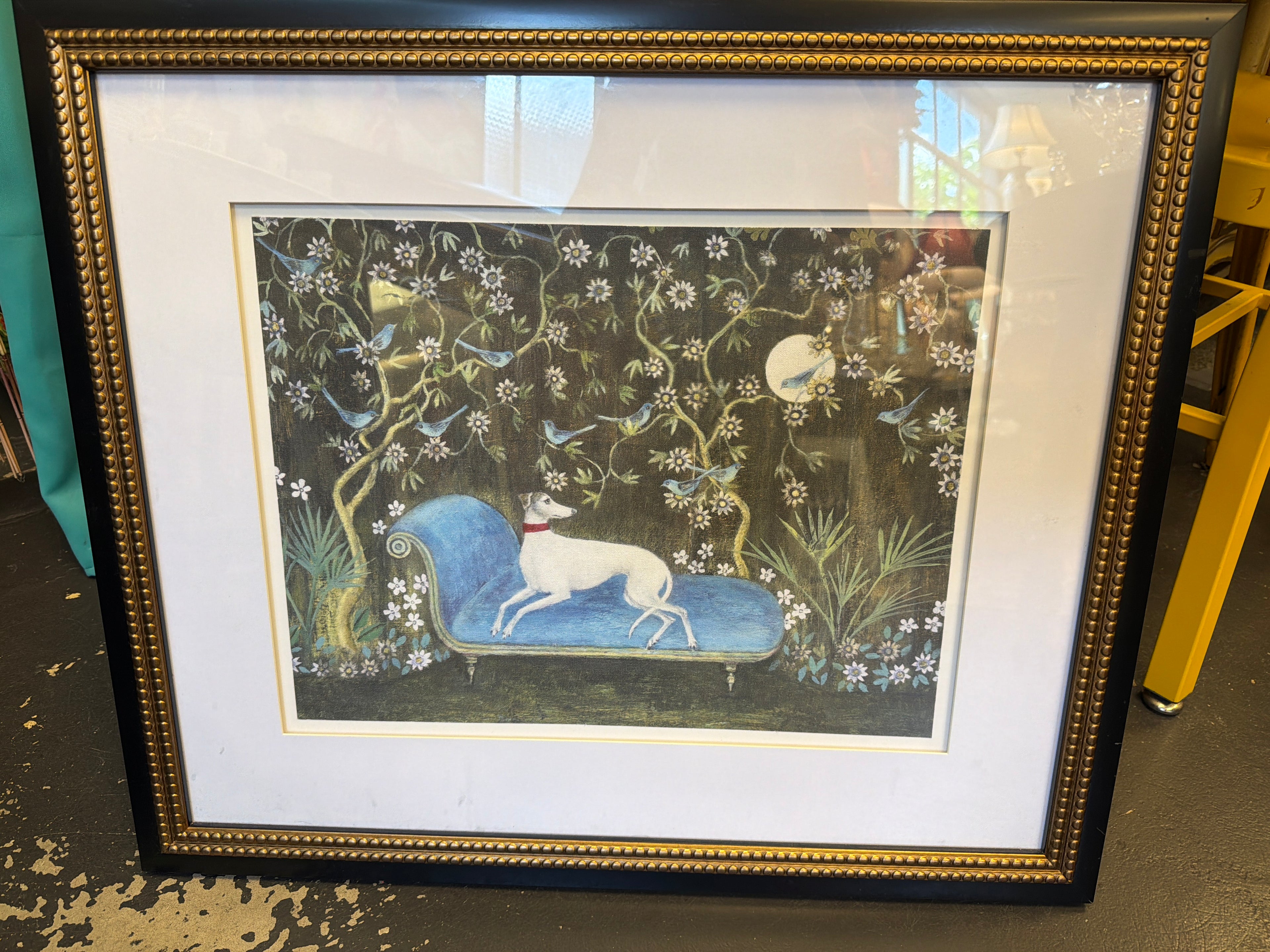 Chinoiserie print white dog on a blue chaise lounge.