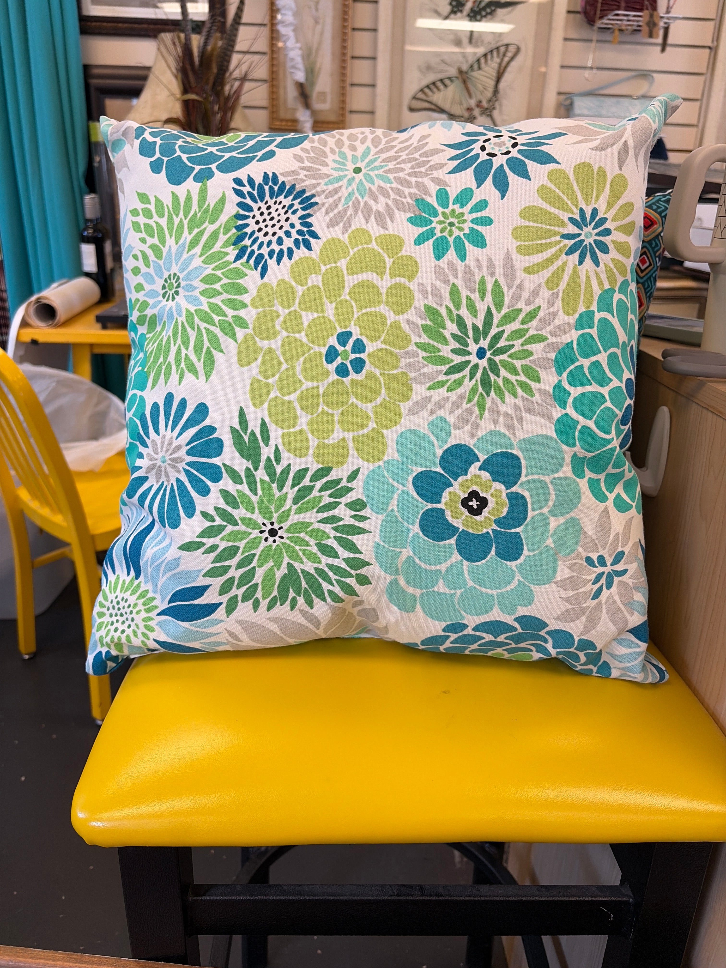 Throw pillow in shades of green, blue and turquoise flowers